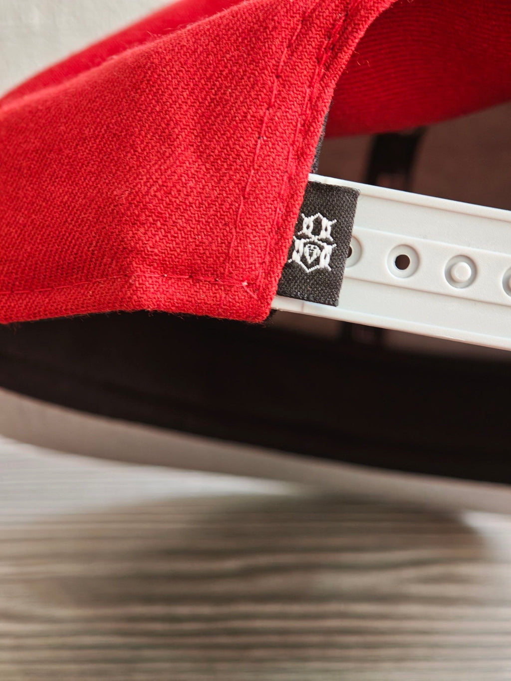 New Era grey and red snapback cap with embroidered "REBEL" anchor design and adjustable strap.