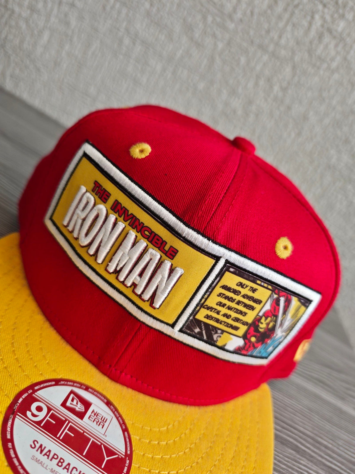 New Era red and yellow snapback hat with embroidered Iron Man patch and Marvel Comics logo.