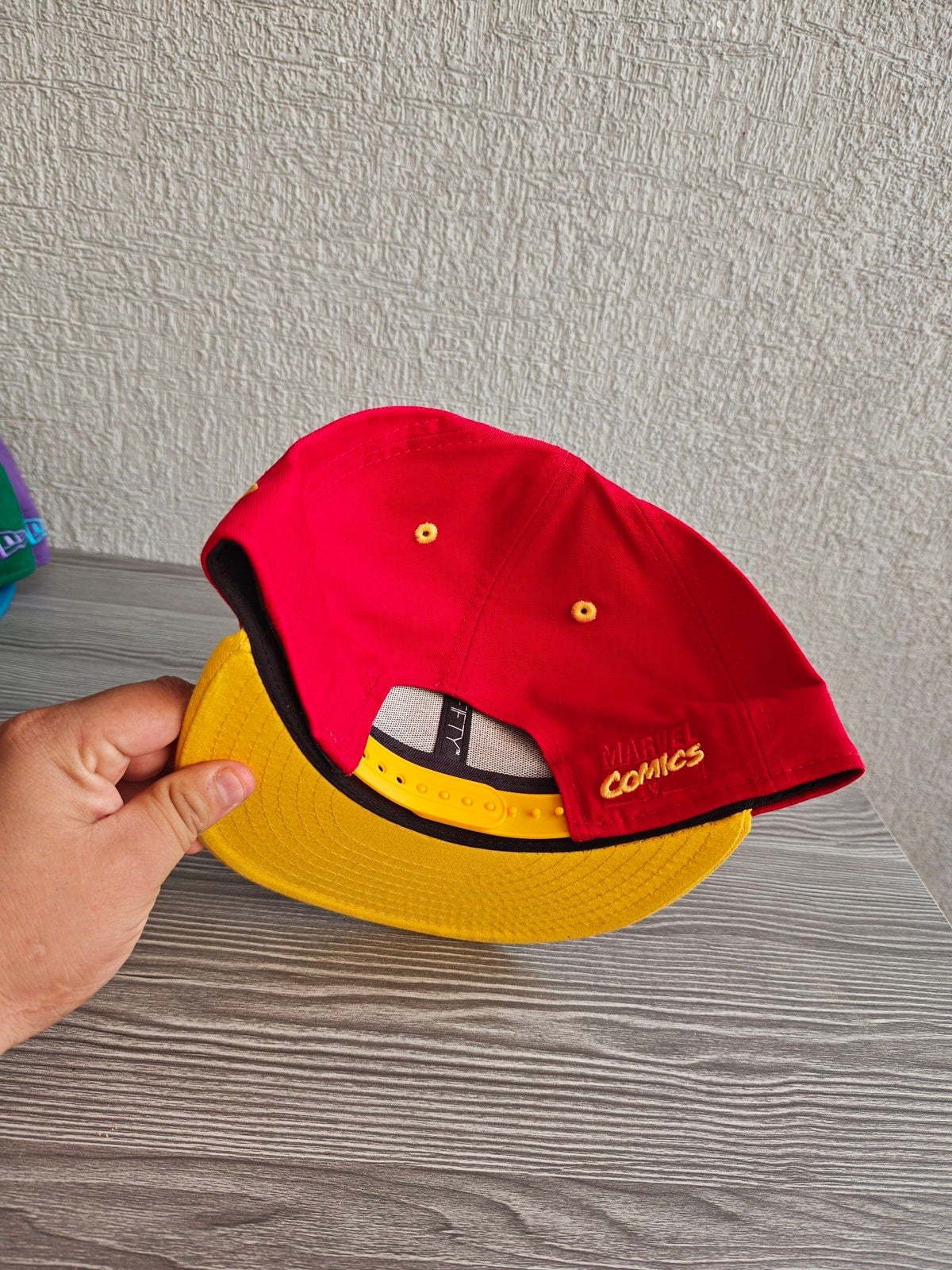 New Era red and yellow snapback hat with embroidered Iron Man patch and Marvel Comics logo.
