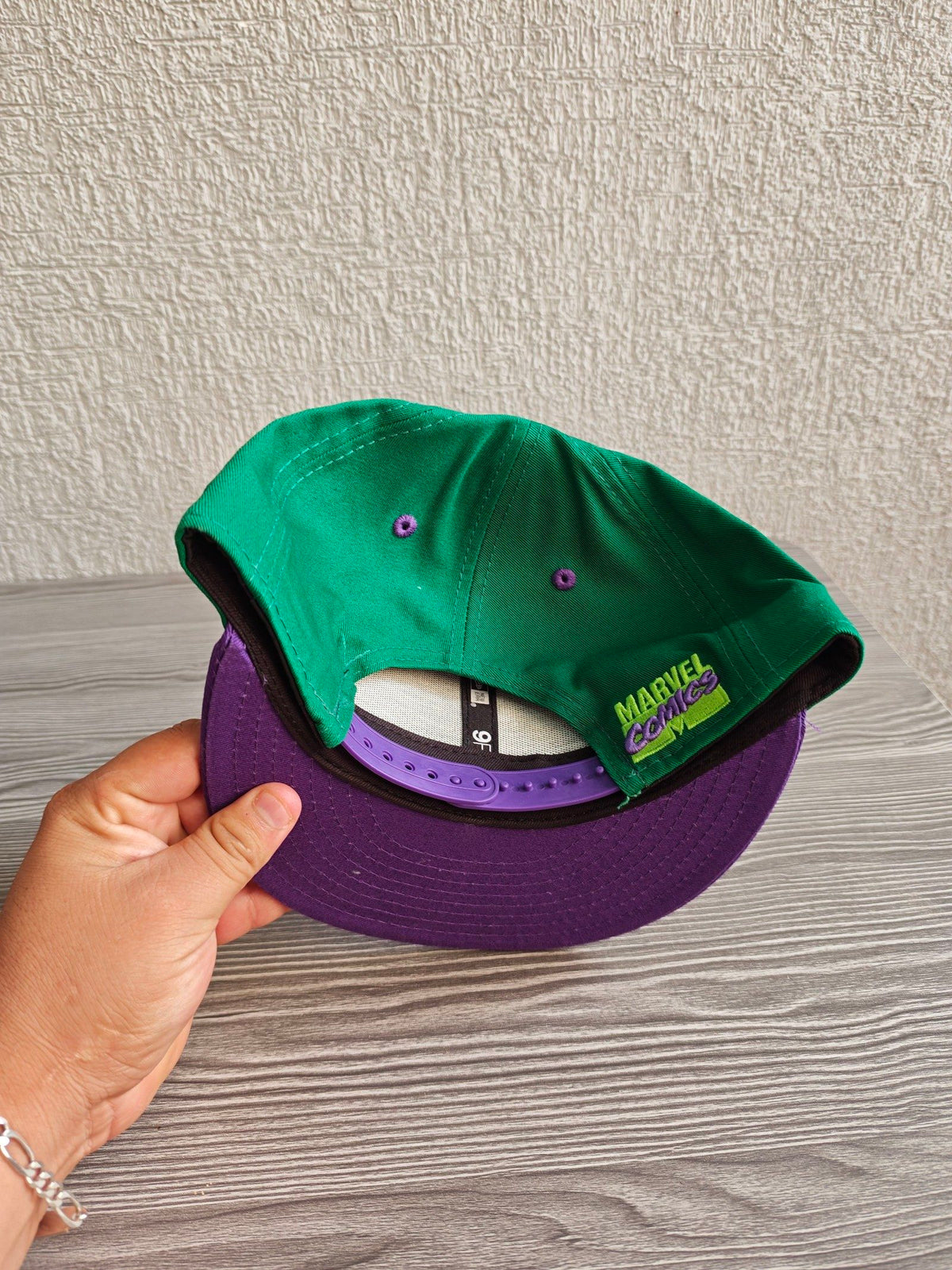 New Era green snapback hat with purple visor and embroidered Incredible Hulk patch.