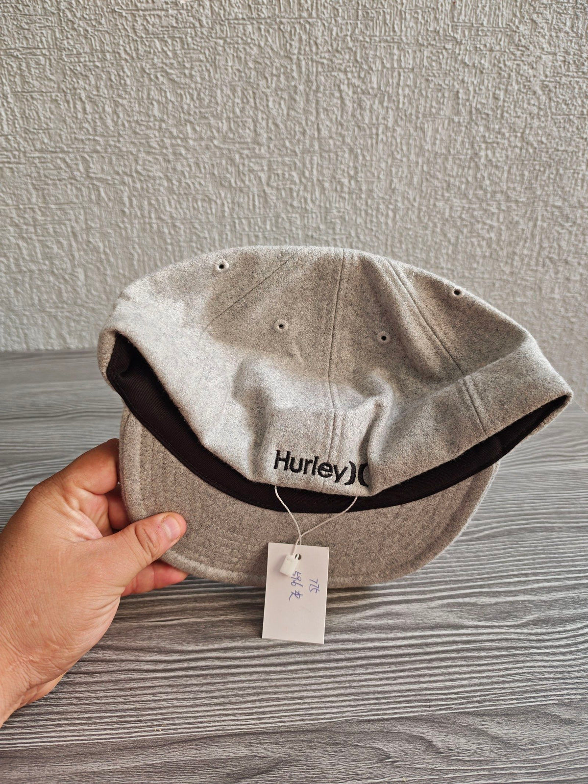 Hurley grey wool baseball cap with black embroidered logo and six ventilation eyelets.