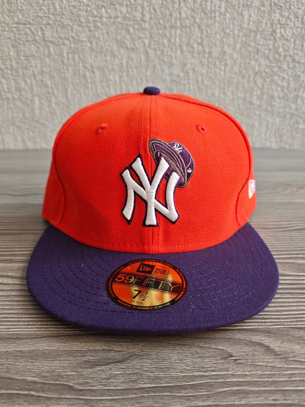 New Era orange and purple New York Yankees cap with embroidered logo and fitted design.