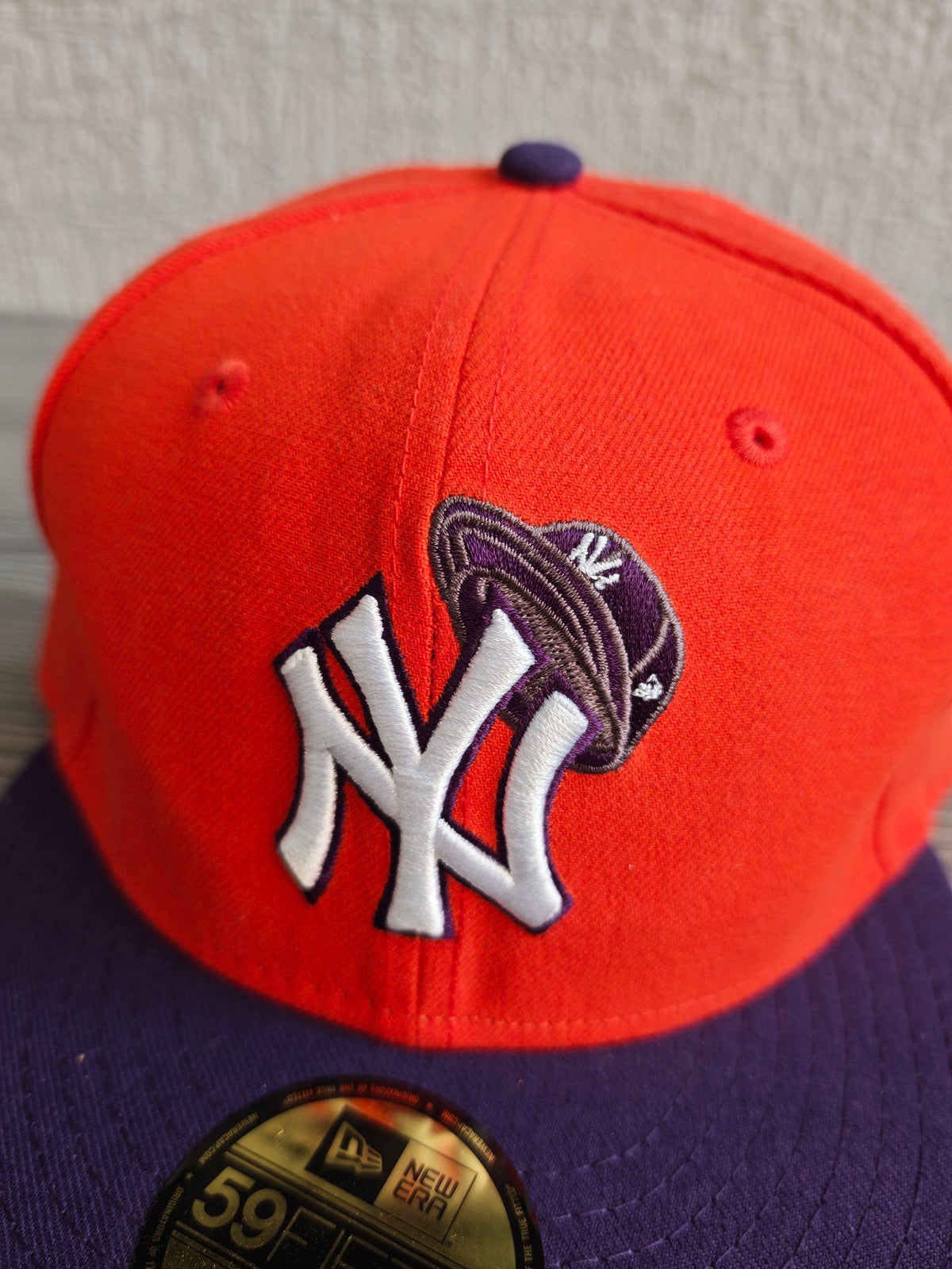 New Era orange and purple New York Yankees cap with embroidered logo and fitted design.