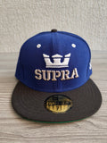 New Era blue and black fitted hat with white embroidered Supra logo and green underside.