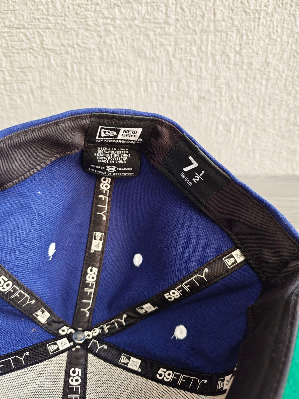 New Era blue and black fitted hat with white embroidered Supra logo and green underside.