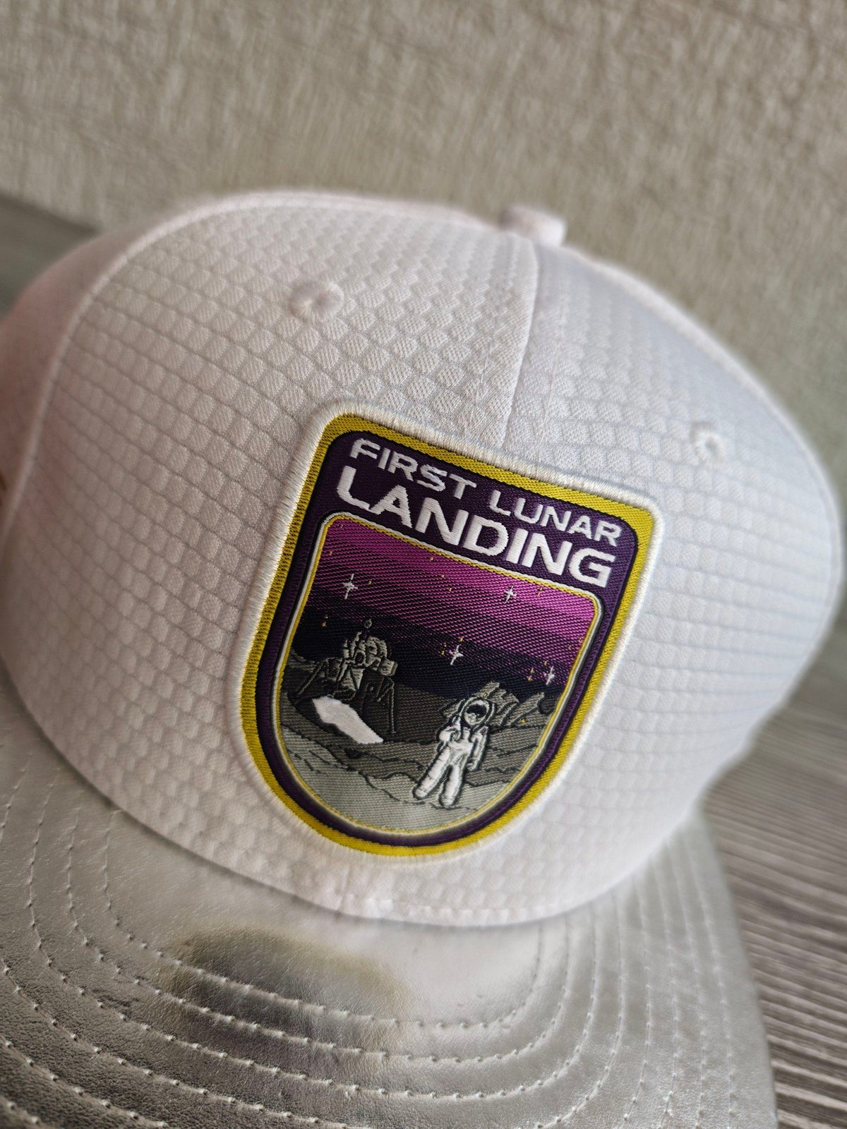 New Era red snapback cap with white textured fabric and embroidered lunar landing patch.