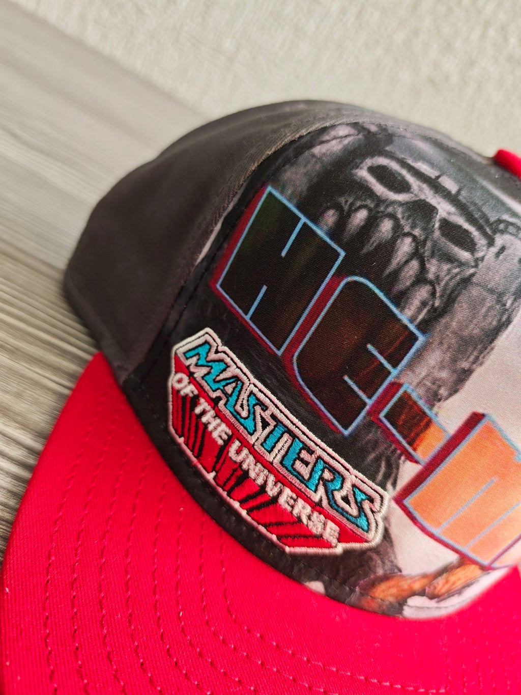 New Era grey snapback cap with red flat brim and Masters of the Universe graphic.