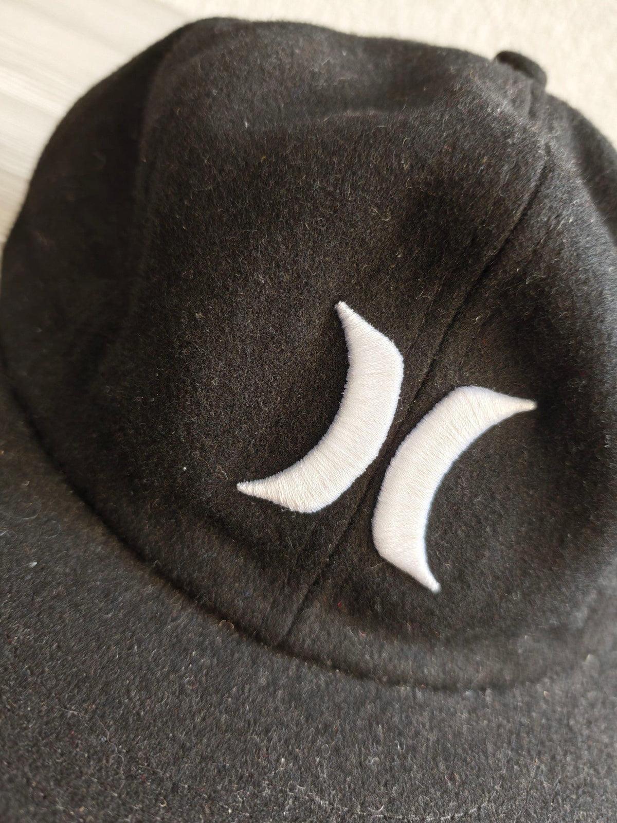 Hurley black fitted cap with white embroidered logos, 100% wool, New Era model.
