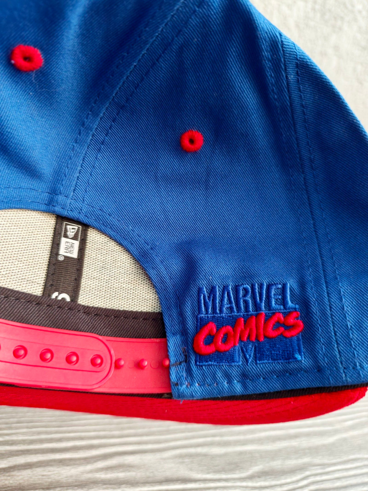 New Era blue and red snapback hat with Captain America comic patch and Marvel logo.