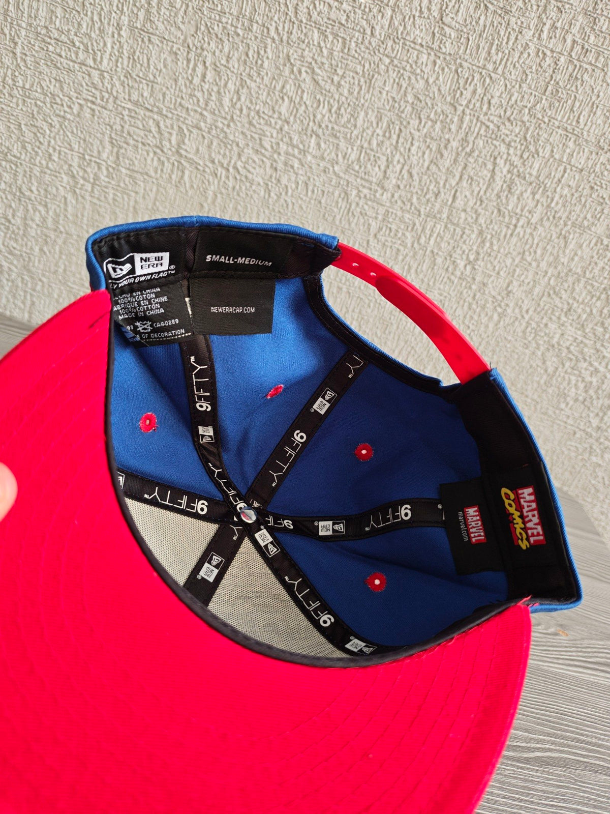 New Era blue and red snapback hat with Captain America comic patch and Marvel logo.