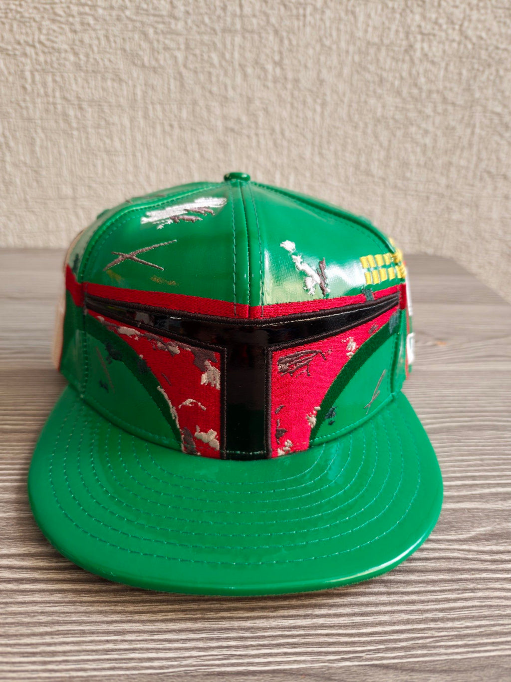 New Era black and green fitted cap with Boba Fett helmet design and space-themed lining.