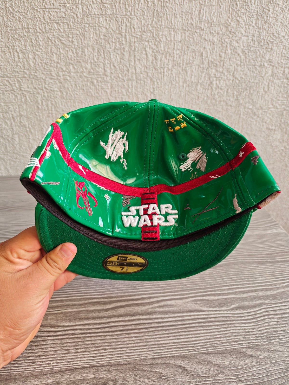 New Era black and green fitted cap with Boba Fett helmet design and space-themed lining.