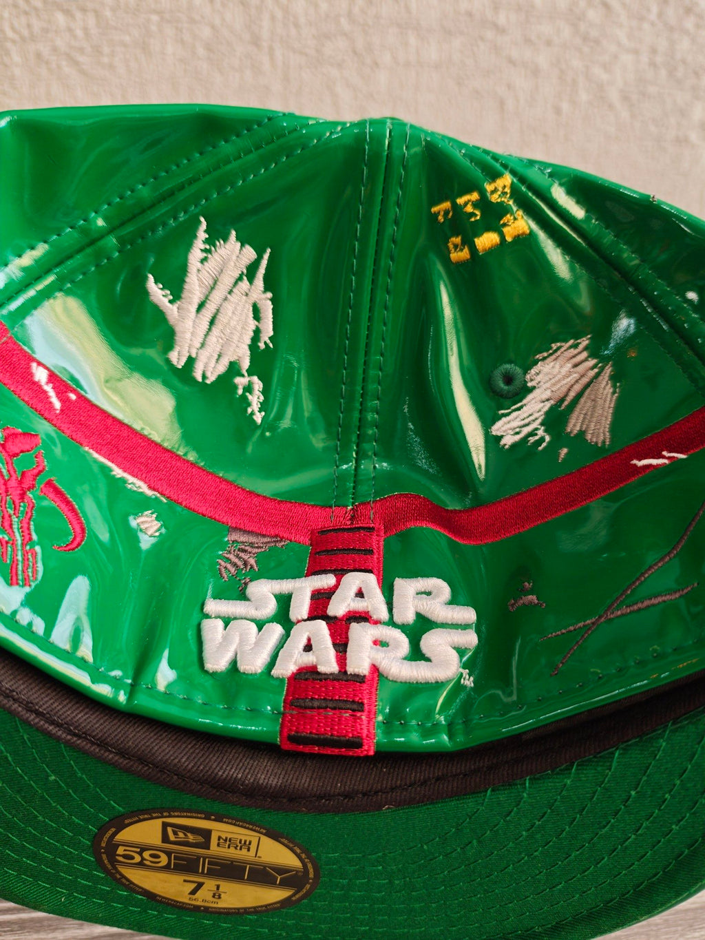 New Era black and green fitted cap with Boba Fett helmet design and space-themed lining.