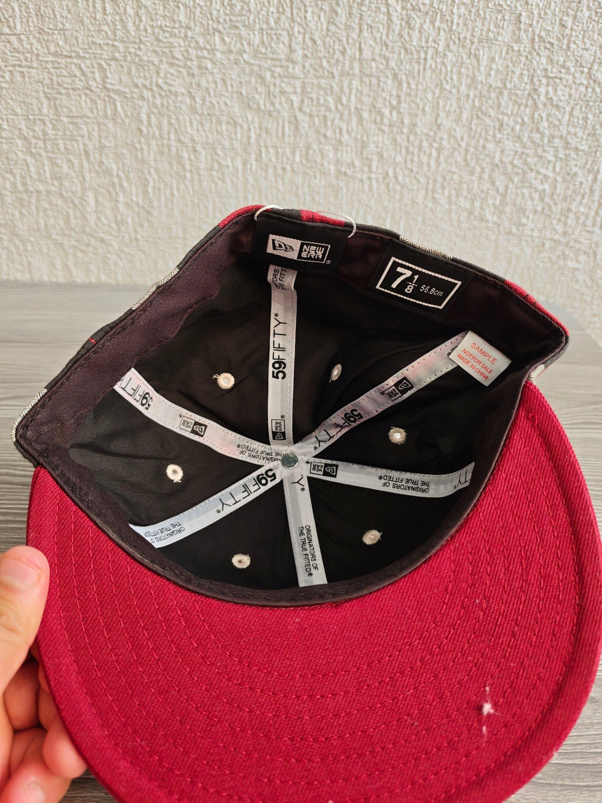 New Era red and cream fitted cap with CA logo and multicolored plaid pattern.