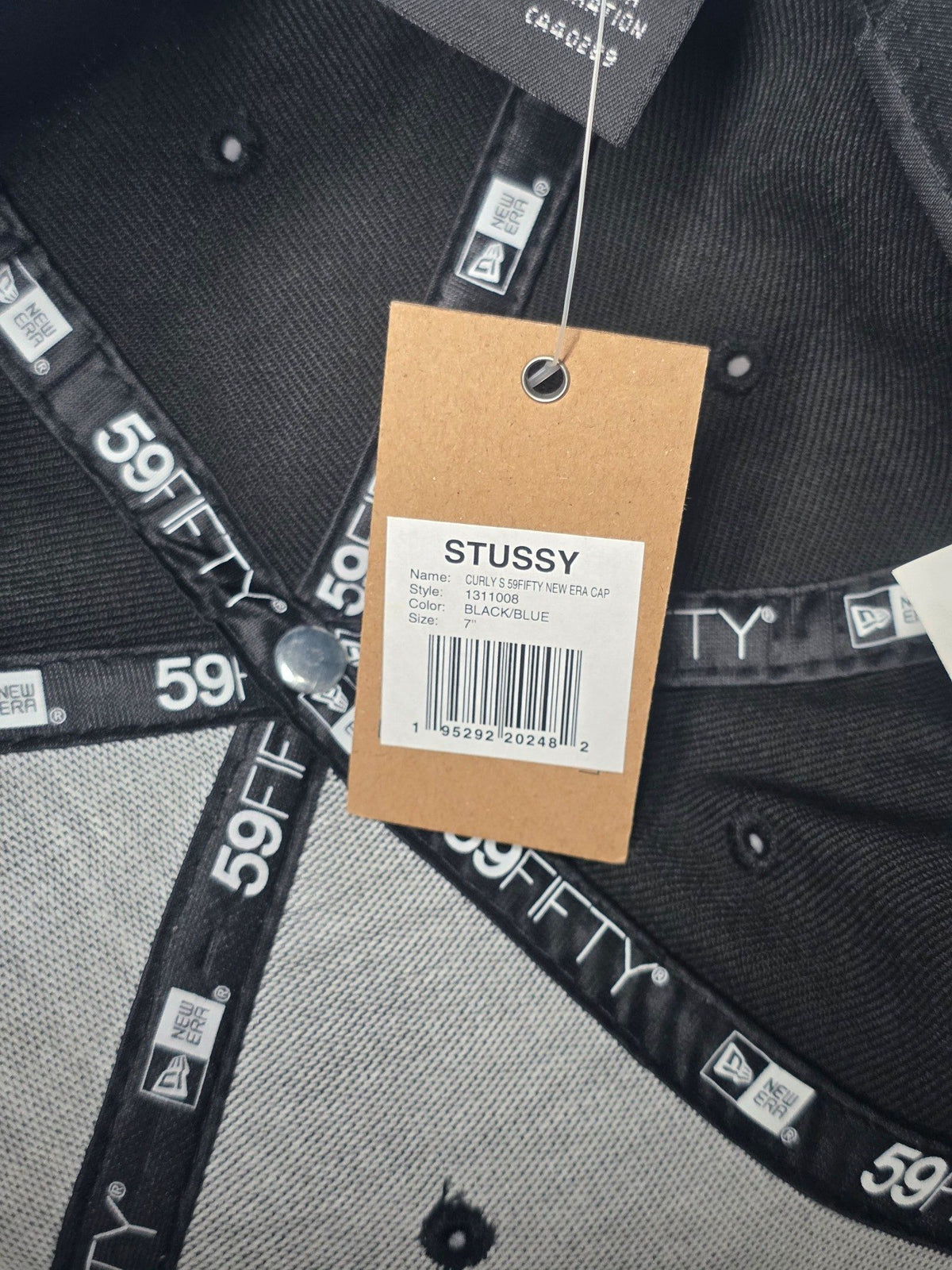Stüssy black and blue 59FIFTY cap with curly S logo and white detailing.