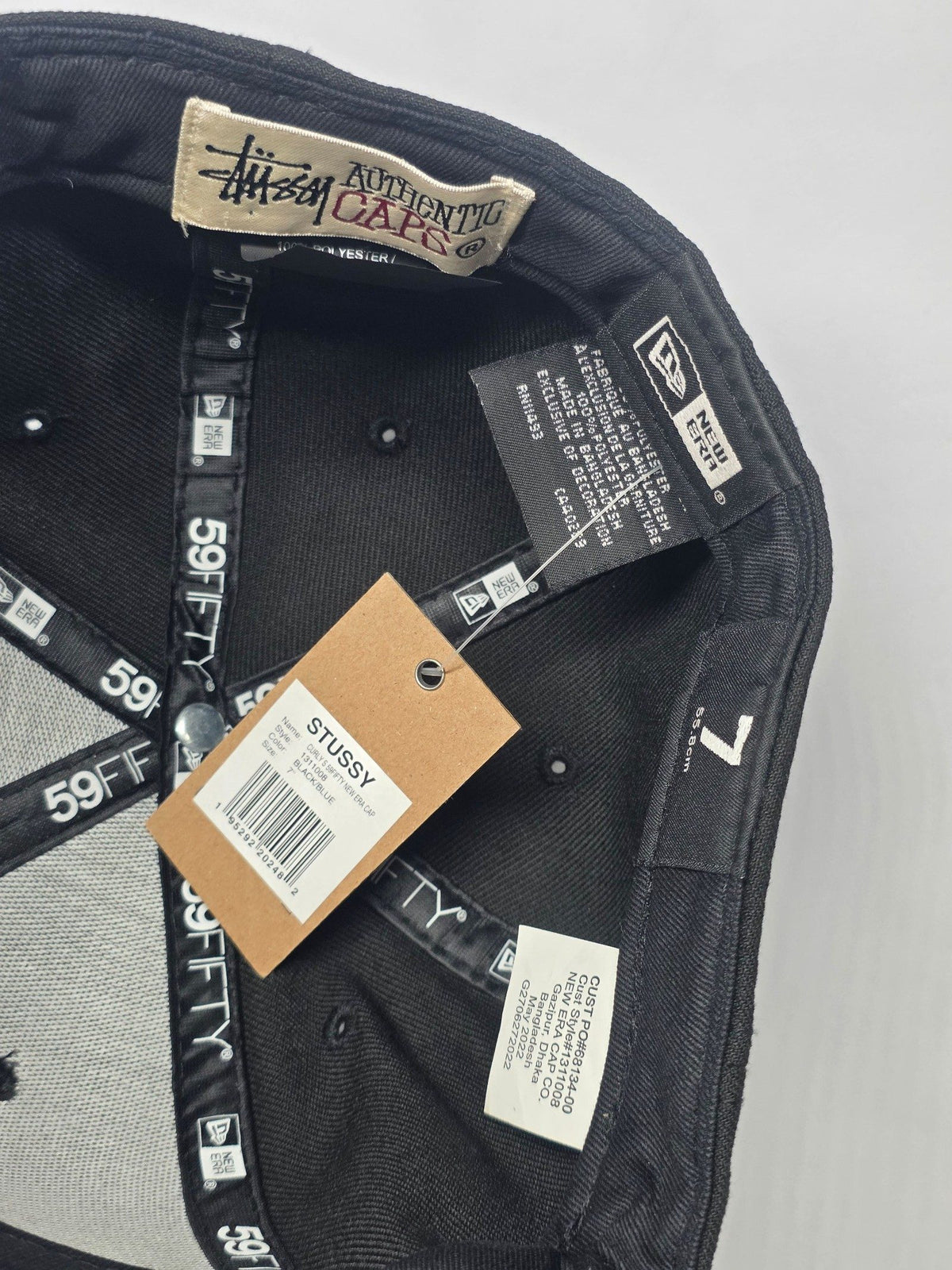 Stüssy black and blue 59FIFTY cap with curly S logo and white detailing.